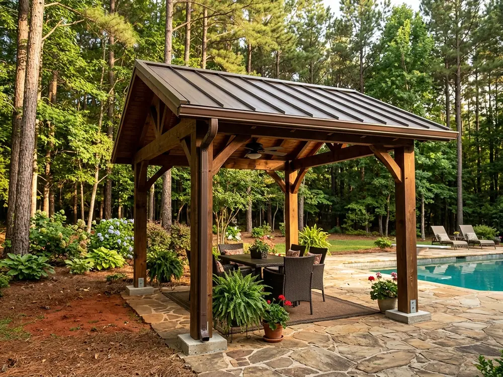 Freestanding patio cover with a bronze metal roof on wood posts beside a pool